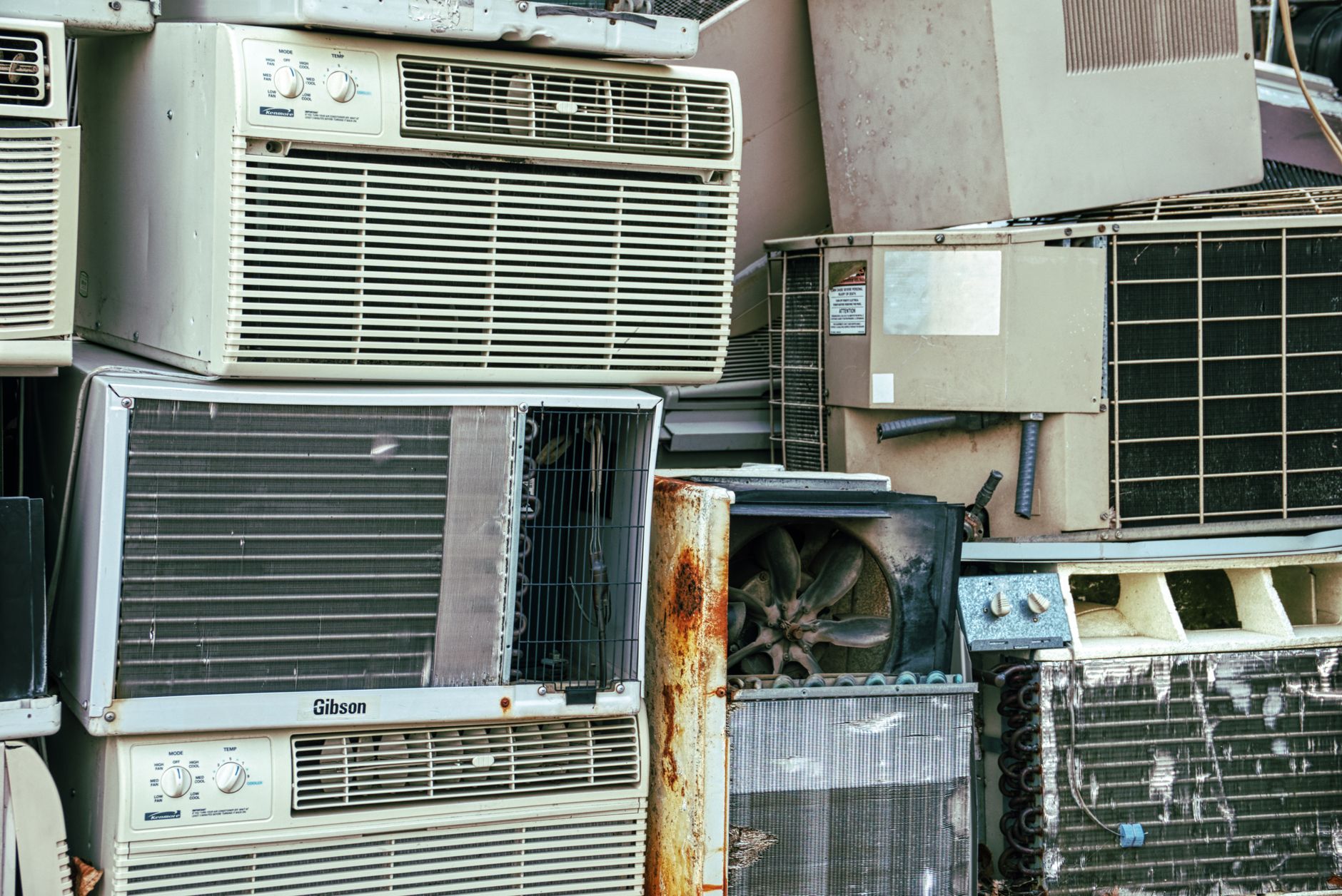 Broken and rusted appliances piled outdoors, similar to old units cleared from Vero Beach homes